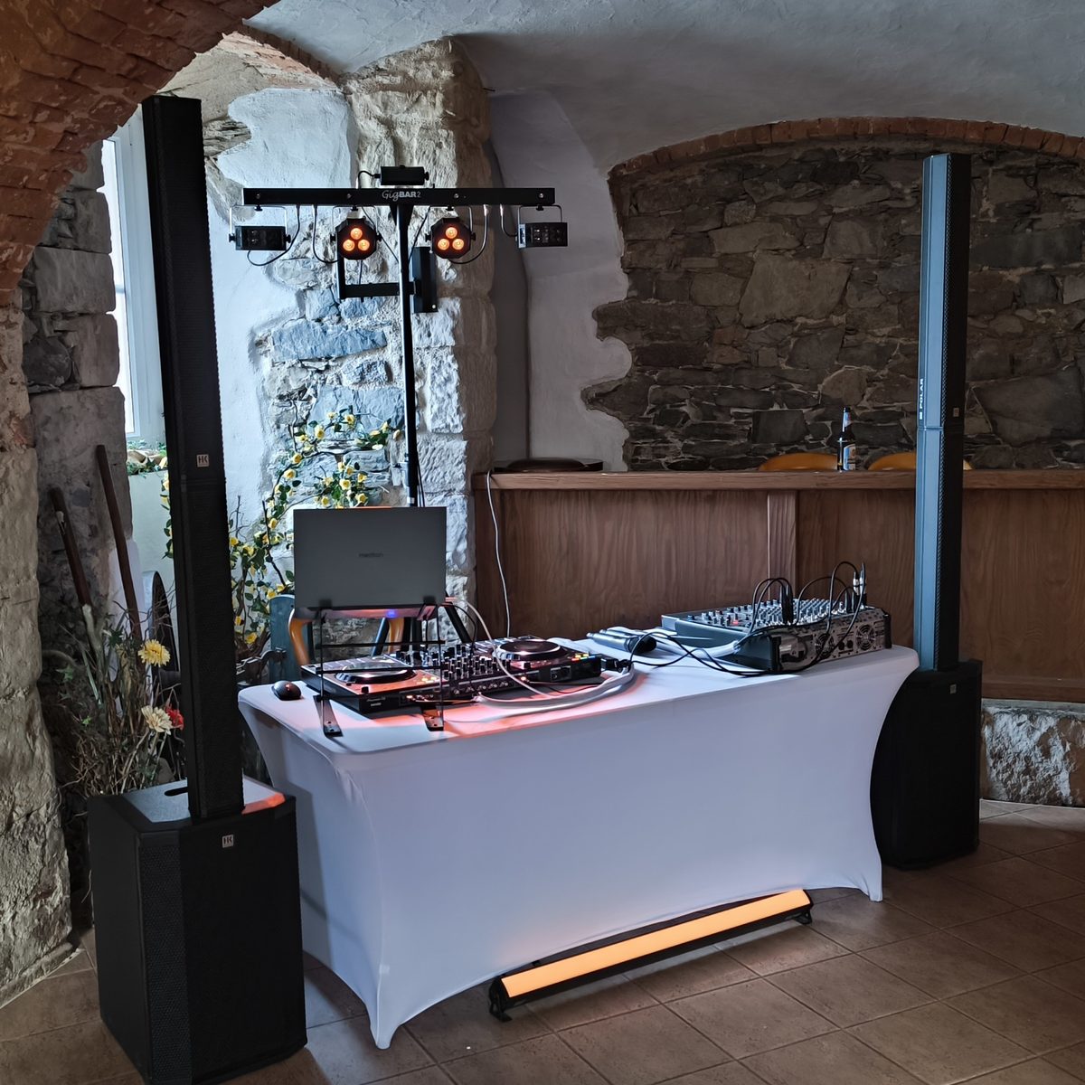 DJ-Aufbau mit Lichtanlage und Boxen in einem historischen Gewölberaum